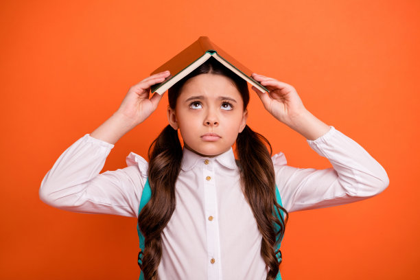 近距离的照片迷人的孩子，小人们感到失望，抬头看穿着白色时尚的衣服上衣背包背包背包孤立的橙色背景图片下载