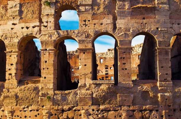 在蓝色的天空和缕缕的云映衬下，圆形竞技场的拱门。意大利罗马帝国古城和罗马的主要旅游景点。晴朗的秋日图片下载