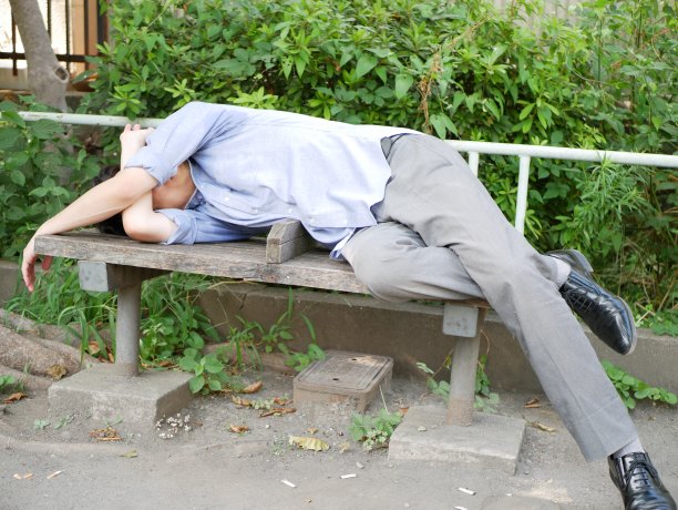 一个年轻人躺在长凳上图片下载