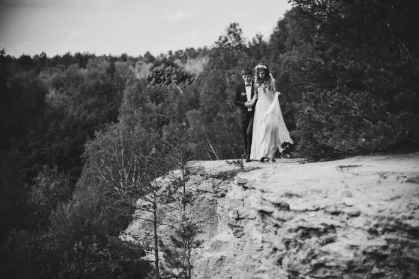 这对夫妇在森林里感受大自然。一个迷人的新娘拥抱新郎的肖像。婚礼仪式。新婚夫妇在户外结婚。黑白照片。图片下载