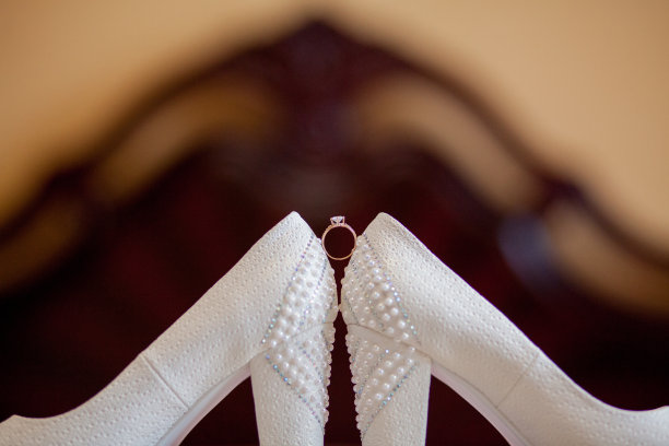 一双白色的结婚鞋，脚凳上有戒指图片下载