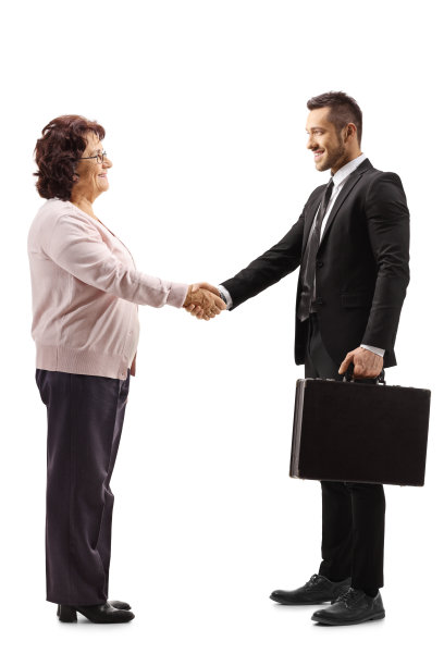 一位资深女士和一位拿着公文包的年轻商人握手图片下载