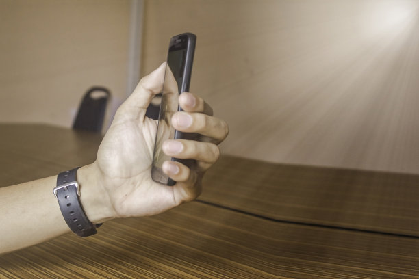 给商人手表和手持智能手机用手指触屏图片下载