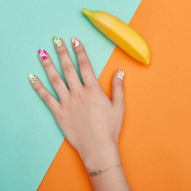 手妆指甲着色和护理，专业的美甲护理产品。手躺在彩色纸背景上图片下载