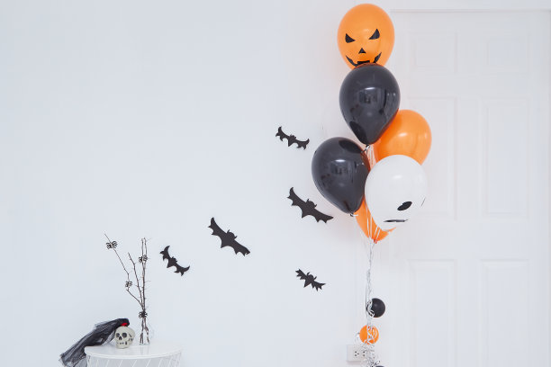 节日，装饰和派对概念，黑色和白色的气球万圣节与黑色飞行蝙蝠在白色的背景图片下载