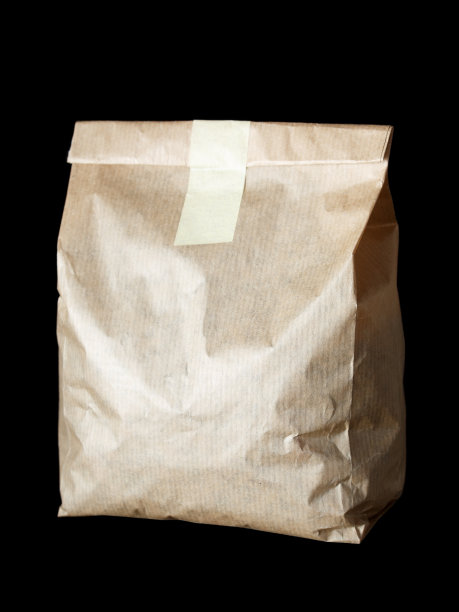 新的空白纸袋，没有铭文和标志。由白色牛皮纸制成。孤立在黑色背景上。图片下载