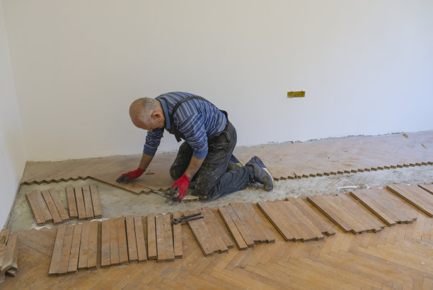 经验丰富的木匠正在通过更换地板来翻新房子图片下载