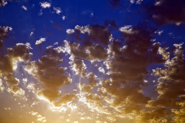 即时照片，色调图像。美丽的暴风雨日落天空。多云的抽象背景。夕阳的颜色。黑色的云。橙色和黄色日落。图片下载