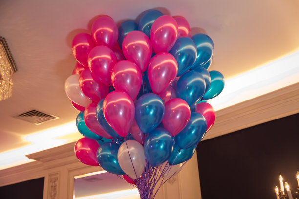 气球在蓝天上欢度蓝天。一堆粉色和蓝色的气球。幸福、欢乐、爱情、生日、婚礼的概念。蓝色和粉色的气球在天空中飞翔。图片下载