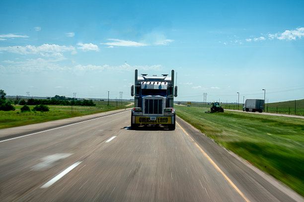 长途半挂卡车在四车道的高速公路上加速运送货物图片下载