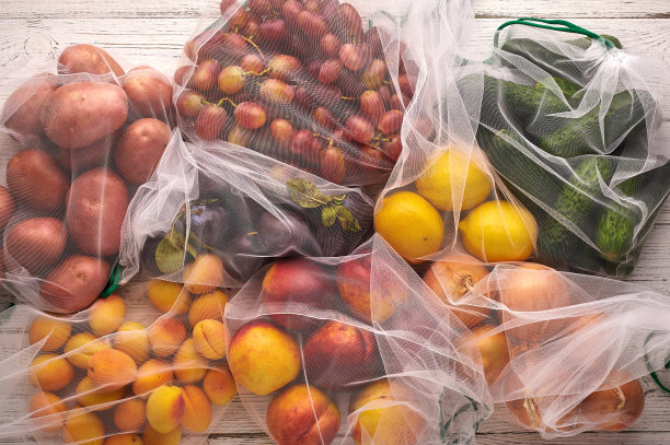 水果和蔬菜在可重复使用的环保袋在白色木制背景。塑料是免费的。图片下载