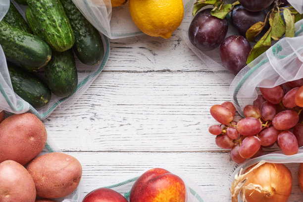 框架水果和蔬菜在可重复使用的环保袋在白色木制背景。图片下载