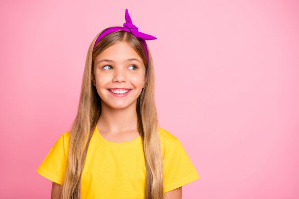 照片善良可爱，高兴，开朗的女孩看了看一些东西，而孤立的粉红色背景图片下载