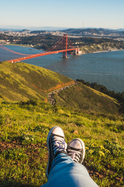 一个阳光明媚的日子，在旧金山金门大桥旁的公园里，一个人的脚的照片图片下载