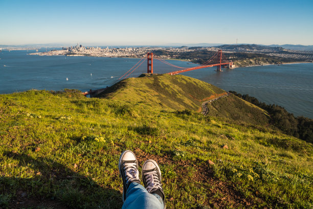 一个阳光明媚的日子，在旧金山金门大桥旁的公园里，一个人的脚的照片图片下载