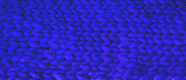 冬天的毛衣设计。蓝色针织羊毛纹理背景。针织物质地。针织针织物背景与浮雕图案。在编织辫子图片下载