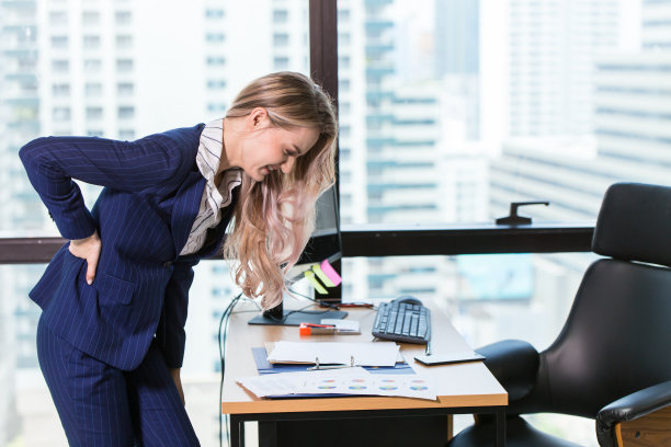 在办公室工作时，商务女性手在背部腰部疼痛，因为肾病图片下载