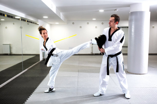 残疾年轻女子做武术跆拳道技术与她的教练图片下载
