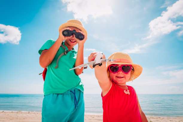 孩子们带着玩具飞机和望远镜在海滩上旅行图片下载