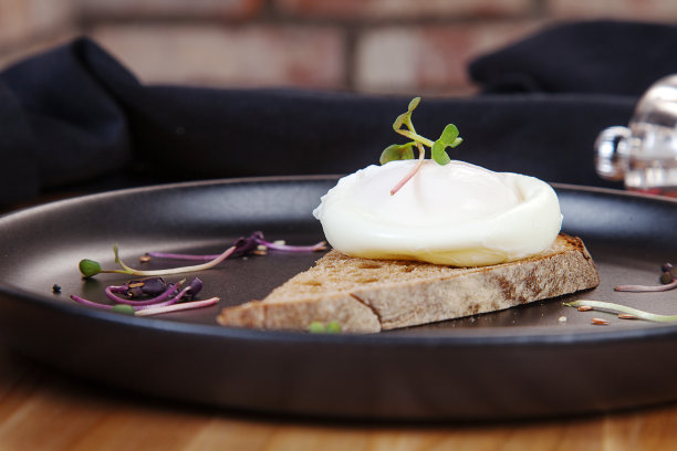 近距离观看美味的早餐吐司和荷包蛋在黑色的盘子。早餐食物。健康平衡的食物。食物照片作为背景。设计复制空间图片下载