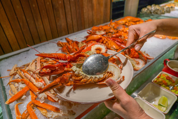顾客在自助餐上挑选龙虾的近距离照片图片下载