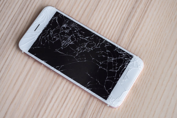 木制背景上的手机屏幕碎玻璃图片下载