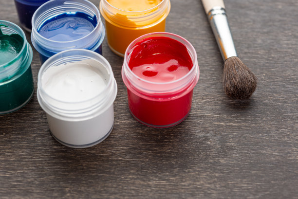 往下看，破旧的木地板上放着三个开着的彩色油漆罐图片下载