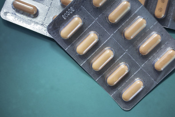 粉红色胶囊在泡罩包装，安排美丽的图案和闪光制药行业概念药，药耐药性抗生素色彩柔和。软的焦点。图片下载