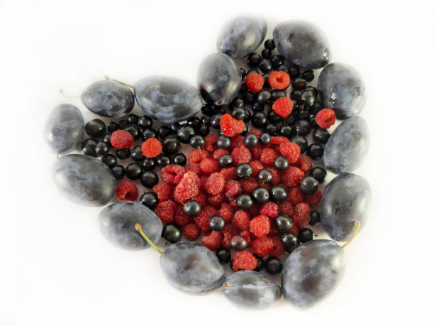 白色背景上的浆果之心。红覆盆子，黑加仑子和李子。美味，维生素食物照片图片下载