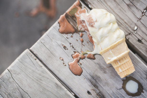 软冰淇淋甜筒溢出并融化图片下载