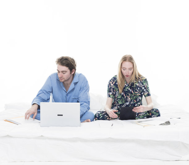 两个人坐在床上工作图片下载