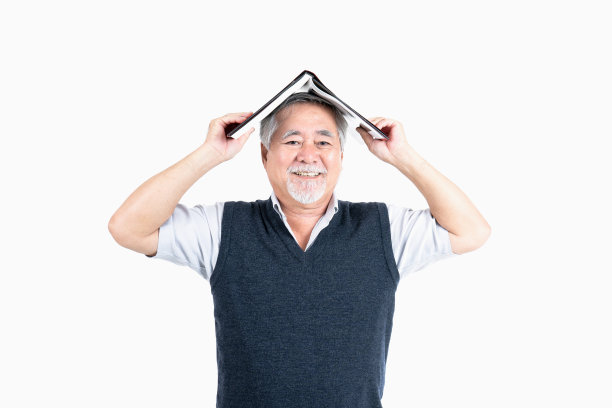 资深男性看相机拿书与你的宣传空间或文字孤立在白色背景，人们的生活理念。图片下载