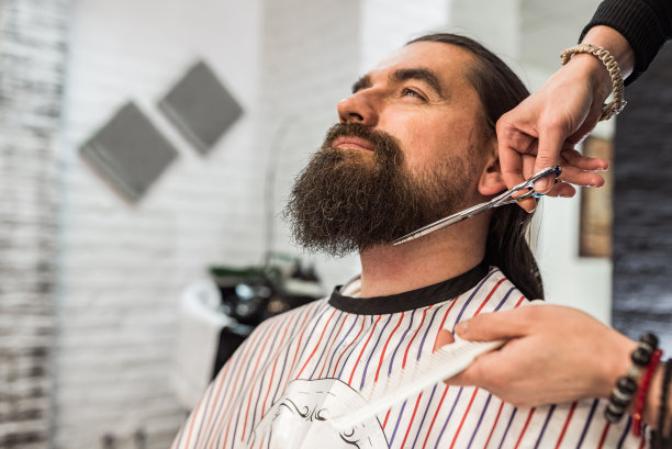 在理发店放松，特写剪胡子。图片下载