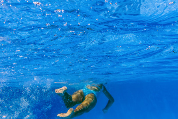 一个女人在深蓝色的水中游泳的水下照片图片下载