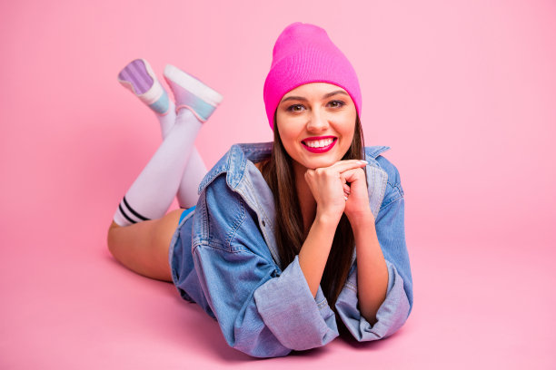 近距离的照片迷人的女士躺着看穿着牛仔牛仔裤袜子孤立在粉红色的背景图片下载