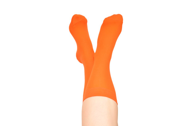 橙色袜子上的女人脚孤立在白色的背景。图片下载