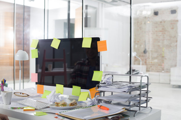 办公室里年轻专业人士凌乱的电脑桌照片图片下载