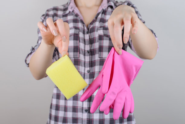 黄色的抹布海绵柔嫩温柔的少女肌肤凌乱的概念。近距离的照片，女士的手指拿着布和橡胶手套不希望清洁房子孤立的灰色背景裁剪复制空间图片下载