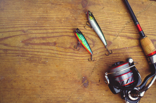 鱼饵用大鱼钩、塑料鱼饵钓具。果冻。摇摆在一个有两个钩子的木头背景上。照片排版，海报，横幅，明信片。一切为了钓鱼图片下载