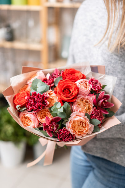 美丽的新鲜切花束混合在女人的手。花店花匠的工作。明亮的多汁的颜色素材图片