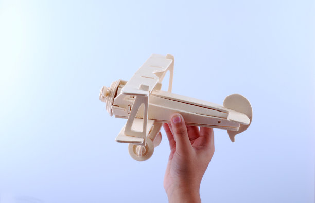 手持一个木制飞机模型孤立在白色背景图片下载