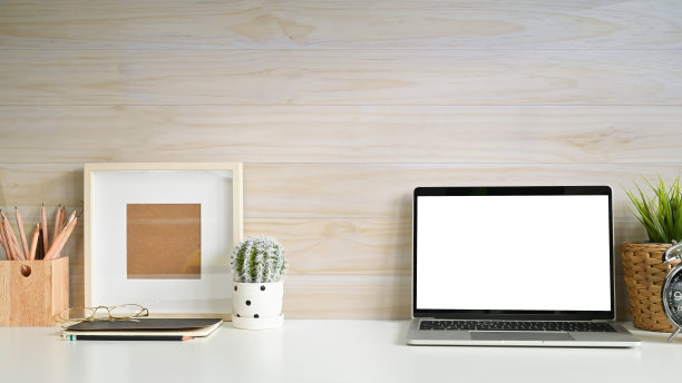 笔记本电脑和办公用品放在白色的工作空间和木墙。图片下载