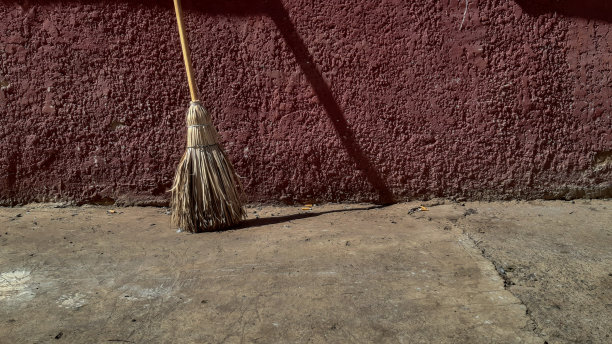 草扫帚倚在墙上图片下载