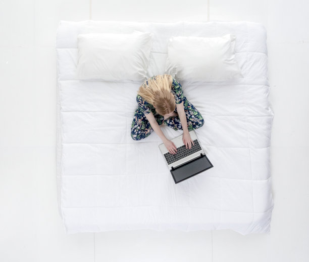 可爱的女性在床上做工作/作业图片下载