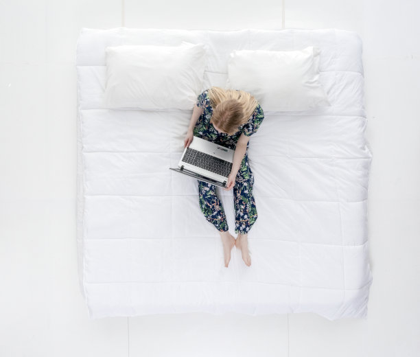 可爱的女性在床上做工作/作业图片下载