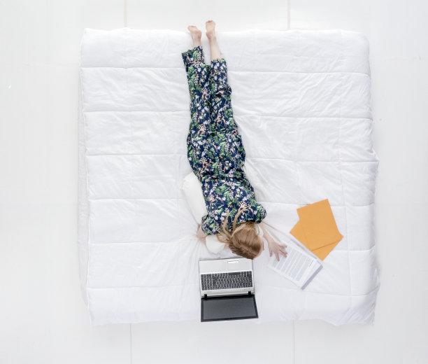 可爱的女性在床上做工作/作业图片下载