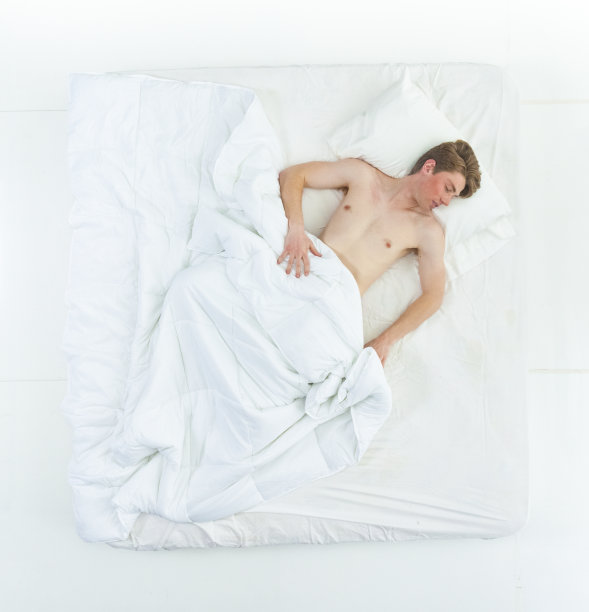 英俊的男人赤裸上身躺在床上图片下载