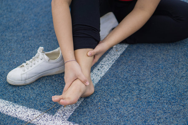 年轻女子触摸她疼痛的脚踝，在锻炼和跑步时脚踝受伤，运动和运动概念。图片下载