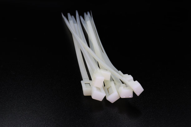 白色尼龙扎带隔离在黑色背景上高分辨率图库。图片下载