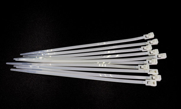 白色尼龙扎带隔离在黑色背景上高分辨率图库。图片下载